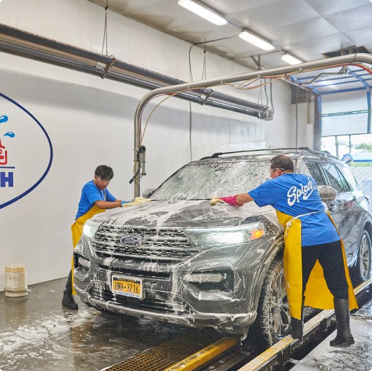 Two men soaping up a car